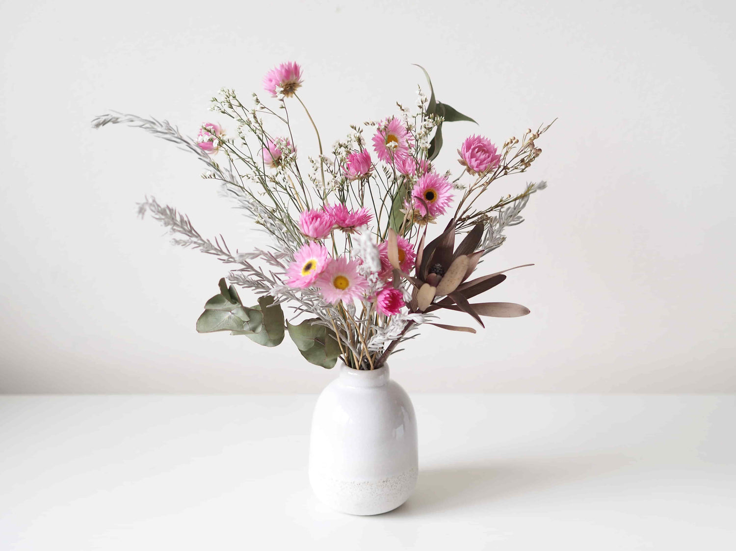 ELISE – dried paper daisies and native grass in a white speckled vase